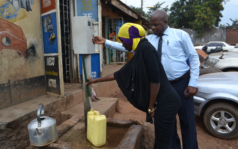 A community member accessing water from a public standpipe in Kisenyi